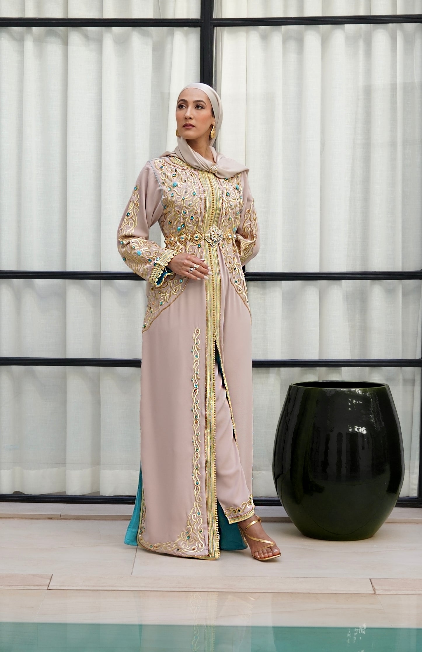 Caftan Aaliya beige en crêpe de soie, orné de broderies or et de perles turquoise. Création artisanale Beldyness style haute couture avec pantalon. Doublure intérieure turquoise.