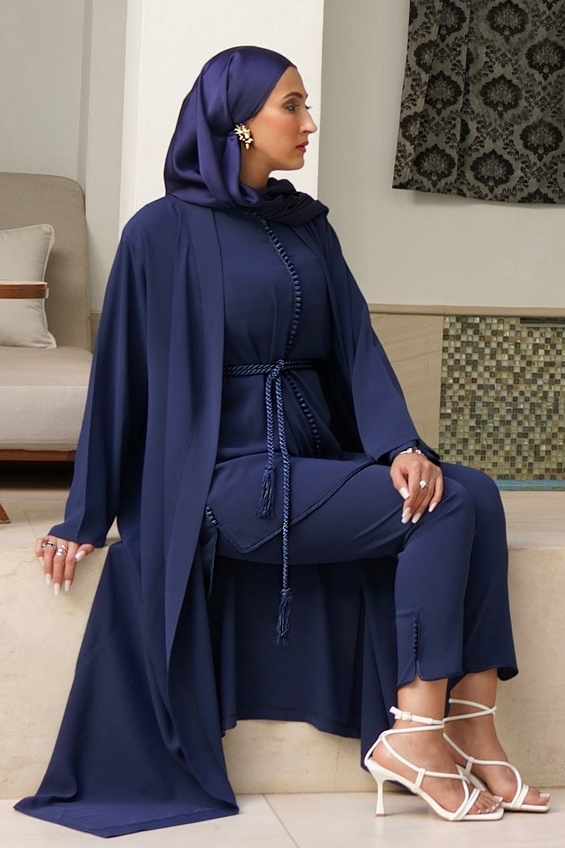 Femme voilée assise portant l'ensemble jabador Liyane bleu marine avec kimono long et ceinture tressée assortie