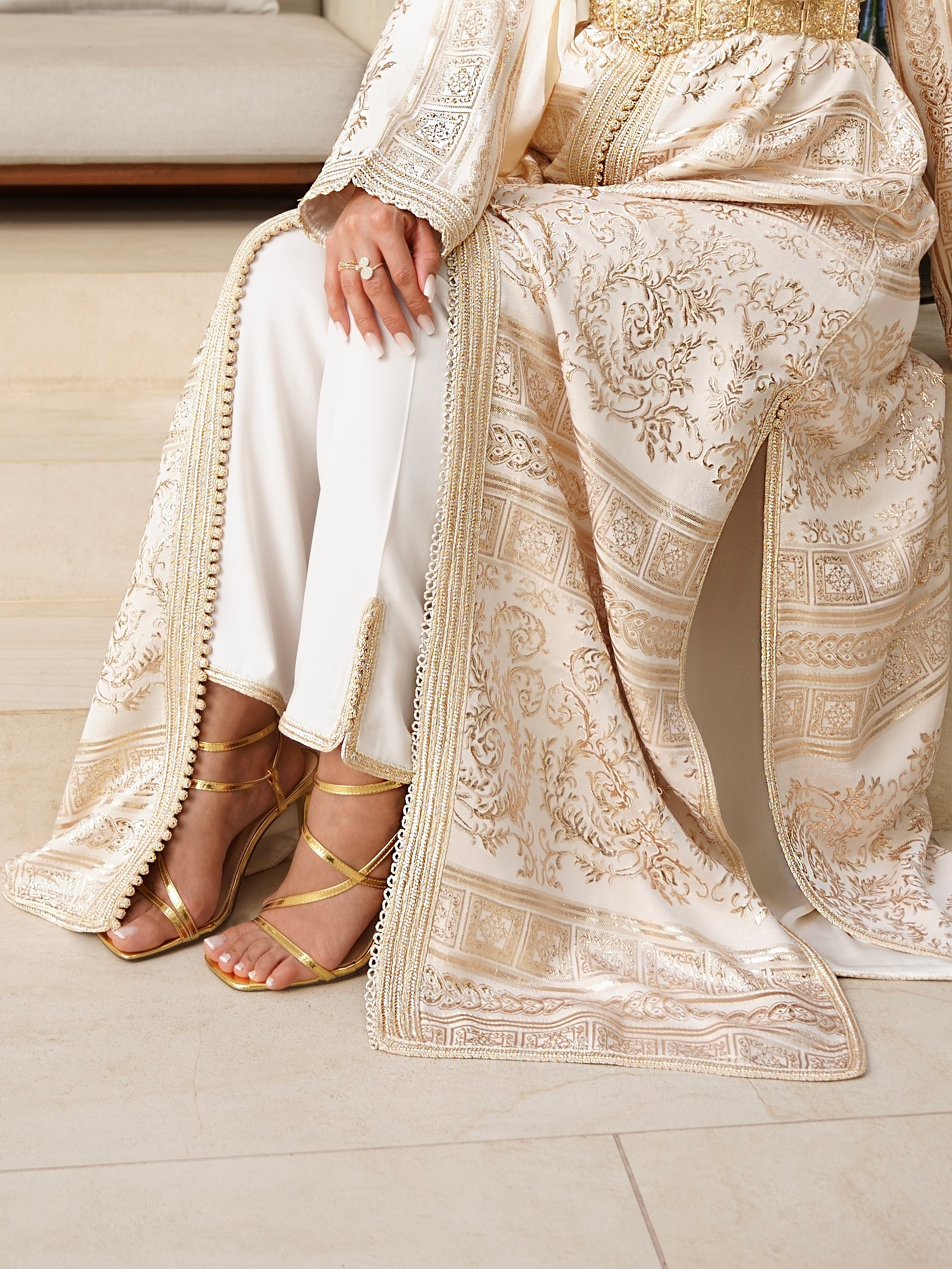 Gros plan du sur le tissu broché luxueux aux motifs dorés tissés. un caftan marocain avec pantalon assorti.