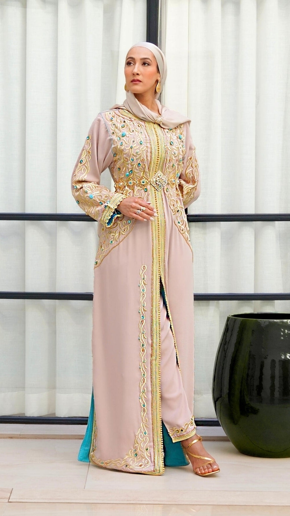Caftan Aaliya beige en crêpe de soie, orné de broderies or et de perles turquoise. Création artisanale Beldyness style haute couture avec pantalon. Doublure intérieure turquoise.