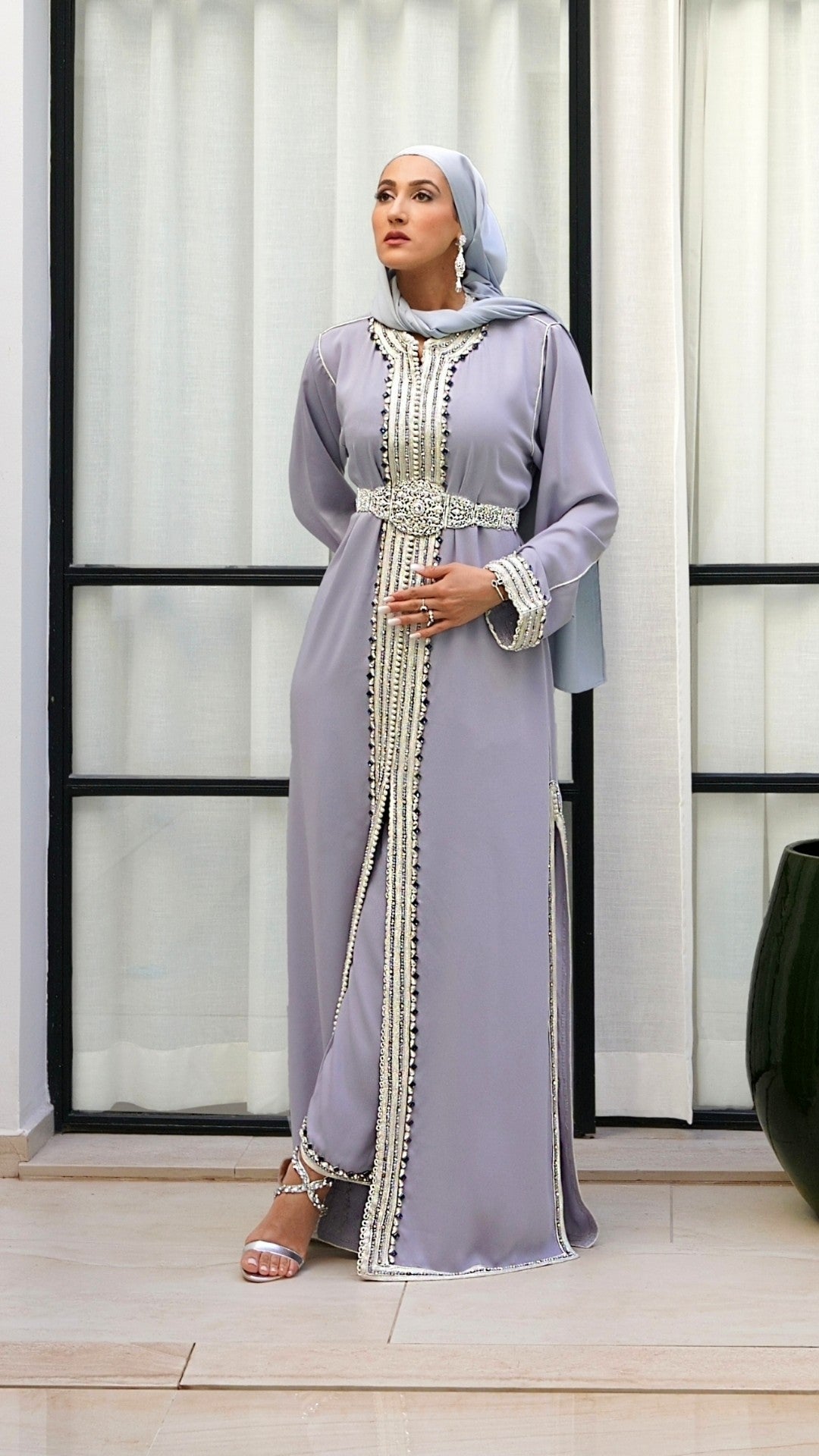 Vue en pied du caftan marocain Jawhara gris orchidée porté debout. Un ensemble Modest Luxury offrant une silhouette fluide et souveraine pour vos événements, signé de la Maison Beldyness.
